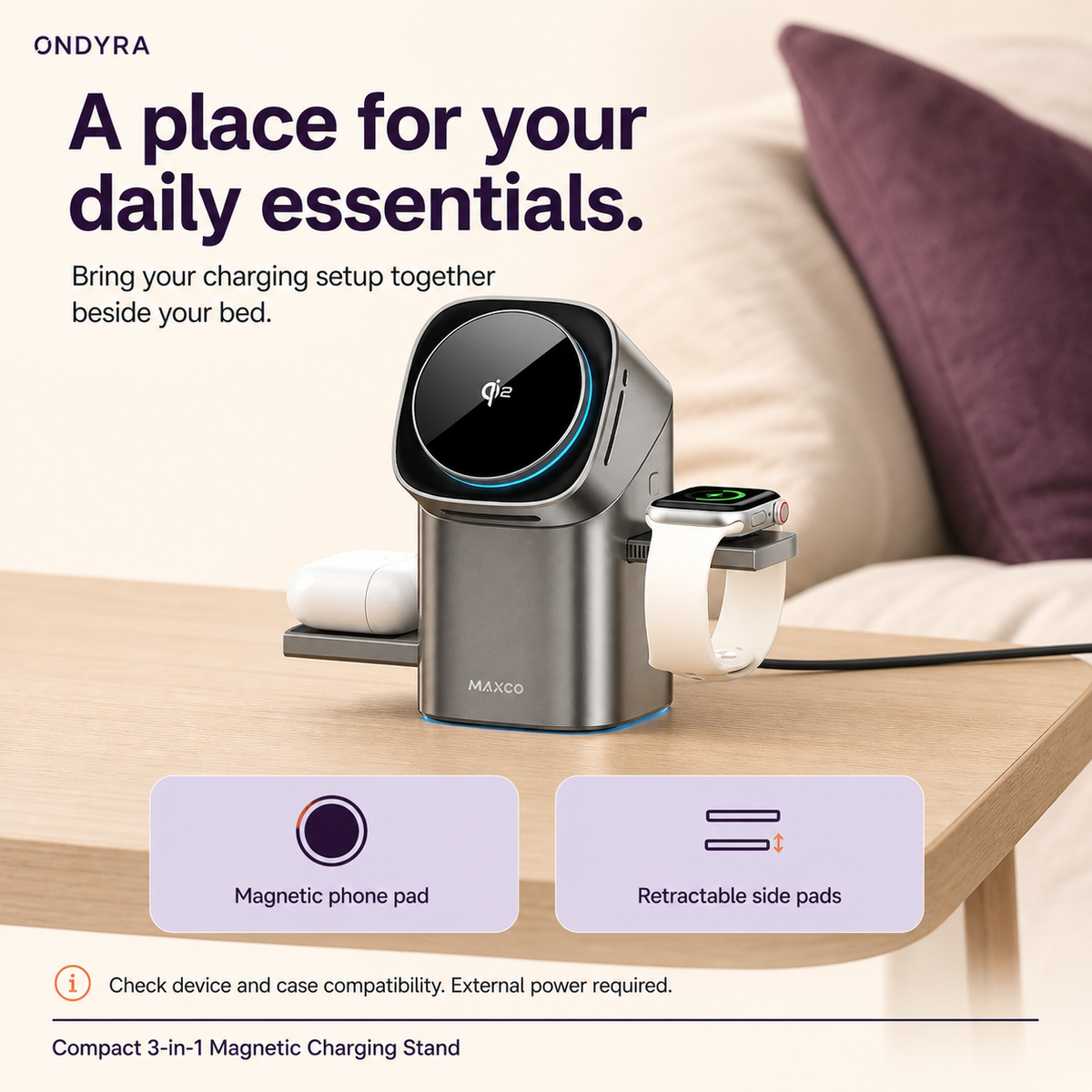 Silver MAXCO magnetic charging stand with watch and earbud case on its side pads beside cream bedding and a plum cushion.